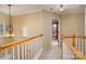 Upstairs hallway with wood railing and light fixture at 5681 Berry Ridge Dr, Harrisburg, NC 28075