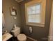 Clean bathroom featuring a toilet, sink, and window with blinds at 604 Kimball St, Kannapolis, NC 28081