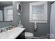 Clean bathroom with gray walls, white sink, and shower/tub combo at 604 Kimball St, Kannapolis, NC 28081