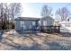 Gray house with a deck, rocking chairs, and gravel driveway at 604 Kimball St, Kannapolis, NC 28081