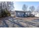 Gray house with a deck, rocking chairs, and gravel driveway at 604 Kimball St, Kannapolis, NC 28081