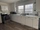 Modern kitchen with white cabinets, stainless steel appliances, and vinyl flooring at 604 Kimball St, Kannapolis, NC 28081