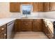 Bright kitchen featuring light wood floors, white countertops, wooden cabinets, and a stainless steel dishwasher at 7753 Old Post Rd, Denver, NC 28037