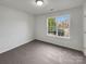 Simple bedroom with gray carpeting and a window overlooking the street at 811 Reigate Rd, Charlotte, NC 28262