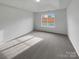 Simple bedroom with gray carpeting and a window offering natural light at 811 Reigate Rd, Charlotte, NC 28262