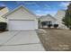 House exterior featuring a white vinyl-sided home with a two-car garage and a small front yard at 811 Reigate Rd, Charlotte, NC 28262