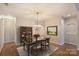 Inviting dining room showcasing a modern chandelier, an elegant display cabinet and neutral wall paint at 8355 Olde Troon Dr, Charlotte, NC 28277