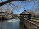 Picturesque lakeside gazebo with a wooden bridge and a fountain offering a peaceful retreat at 8355 Olde Troon Dr, Charlotte, NC 28277