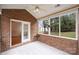 Spacious sunroom with brick walls and backyard access at 8355 Olde Troon Dr, Charlotte, NC 28277