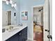 Bathroom features a navy vanity, marble countertop, and a view of a bedroom at 10718 Lederer Ave, Charlotte, NC 28277