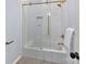 Bathroom with white subway tiles, a soaking tub, and gold fixtures at 10718 Lederer Ave, Charlotte, NC 28277