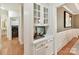 Butlers pantry with glass-front cabinets and hardwood floors at 10718 Lederer Ave, Charlotte, NC 28277