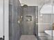 Large walk-in shower with gray tile and gold fixtures at 10718 Lederer Ave, Charlotte, NC 28277