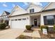 Charming home exterior with a two-car garage, stone accents, and manicured landscaping at 1112 Augustus Beamon Dr, Indian Trail, NC 28079