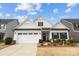 Charming exterior featuring a white facade, well-manicured landscaping, and an attached two-car garage at 1112 Augustus Beamon Dr, Indian Trail, NC 28079