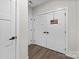 Hallway with a pair of white storage doors, American flag, and wood-look flooring at 1112 Augustus Beamon Dr, Indian Trail, NC 28079