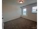 Bedroom with bright natural light from dual windows, carpet flooring and a white closet door at 12131 Plummer Ct # 1, Midland, NC 28107