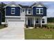 Charming two-story home with a two car garage, manicured lawn, and a blue and gray color scheme at 12131 Plummer Ct # 1, Midland, NC 28107