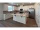 Bright kitchen featuring an island, white cabinets, stainless steel appliances, and wood-look floors at 12131 Plummer Ct # 1, Midland, NC 28107
