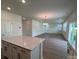 Modern kitchen open to living area with wood-look floors, white cabinets, and an island with quartz countertop at 12131 Plummer Ct # 1, Midland, NC 28107