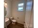 Well-lit powder room with a modern sink, toilet, and a window for natural light at 12131 Plummer Ct # 1, Midland, NC 28107