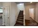 Bright stairway with carpeted steps, white banister, and adjacent entry door to the main living space at 12131 Plummer Ct # 1, Midland, NC 28107