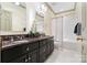 Well-lit bathroom with dual sinks, granite counters, and a tub shower combination at 12201 Pine Valley Club Dr, Charlotte, NC 28277