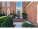 A charming entryway featuring a brick facade, elegant front door, and decorative greenery at 12201 Pine Valley Club Dr, Charlotte, NC 28277