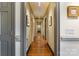 Long hallway with hardwood flooring and neutral walls leads to multiple rooms in the home at 12201 Pine Valley Club Dr, Charlotte, NC 28277