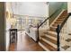 Sun-filled living room with hardwood floors, fireplace, staircase and large arched windows at 12201 Pine Valley Club Dr, Charlotte, NC 28277