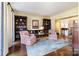 Cozy living room features custom bookcases, hardwood floors, and stylish seating at 12201 Pine Valley Club Dr, Charlotte, NC 28277