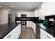 Modern kitchen with white cabinets, stainless steel appliances, and dark countertops at 131 Crownpiece St, Troutman, NC 28166