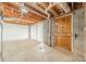 Unfinished basement with concrete floor, exposed duct work, wood door, and painted brick wall at 1486 Amity Church Rd, Denver, NC 28037