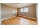 A simple bedroom with wood floors, neutral walls, and a double window at 1486 Amity Church Rd, Denver, NC 28037