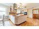 A bright kitchen island featuring a stainless hood, tile backsplash, butcher block countertop and hardwood floors at 1486 Amity Church Rd, Denver, NC 28037