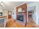 Spacious living room with a brick fireplace, hardwood floors, and a view of the kitchen at 1486 Amity Church Rd, Denver, NC 28037