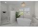 Elegant bathroom with soaking tub, walk-in shower, and window at 15409 Brem Ln, Charlotte, NC 28277