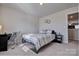 Bright bedroom with a queen-size bed, desk, and adjacent door at 16303 Cozy Cove Rd, Charlotte, NC 28278