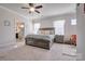 Main bedroom with gray platform bed, ceiling fan, and access to en suite at 16303 Cozy Cove Rd, Charlotte, NC 28278