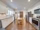 Modern kitchen with granite countertops, stainless steel appliances, and a farmhouse sink at 17 Walnut St, China Grove, NC 28023