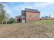 View of the rear exterior of the brick house showing its sloped yard and access to the lower level at 1915 Cavendale Dr, Rock Hill, SC 29732