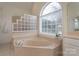 Bathroom featuring a large soaking tub with natural light, and neutral tile design at 1915 Cavendale Dr, Rock Hill, SC 29732