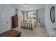 Tranquil bedroom with light blue walls featuring a brass bed frame, dresser, and large windows at 1915 Cavendale Dr, Rock Hill, SC 29732