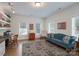 Cozy living room features hardwood floors, built-in shelves, large windows, crown molding, and a stylish blue couch at 1915 Cavendale Dr, Rock Hill, SC 29732