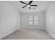 Well-lit bedroom featuring a ceiling fan and two windows at 3026 Uxbridge Woods Ct, Charlotte, NC 28205