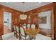 Formal dining room with wood paneling, chandelier, and view of kitchen at 303 Hillside Ave, Charlotte, NC 28209