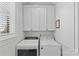 Bright laundry room with washer, dryer, and ample cabinets at 303 Hillside Ave, Charlotte, NC 28209