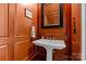 Elegant powder room with pedestal sink and wood paneling at 303 Hillside Ave, Charlotte, NC 28209