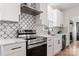 Modern kitchen with white shaker cabinets, stainless steel appliances, and geometric backsplash at 303 S Greene St, Wadesboro, NC 28170