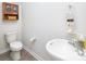 A modern half-bathroom with a pedestal sink, toilet, and towel rack, decorated in neutral tones at 3148 Ora Smith Rd, Lincolnton, NC 28092